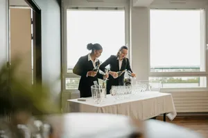 Zwei Kellnerinnen füllen Sekt in Gläser