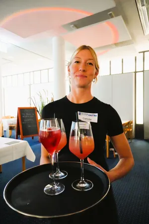 Eine Frau serviert Cocktails auf einem Tablett